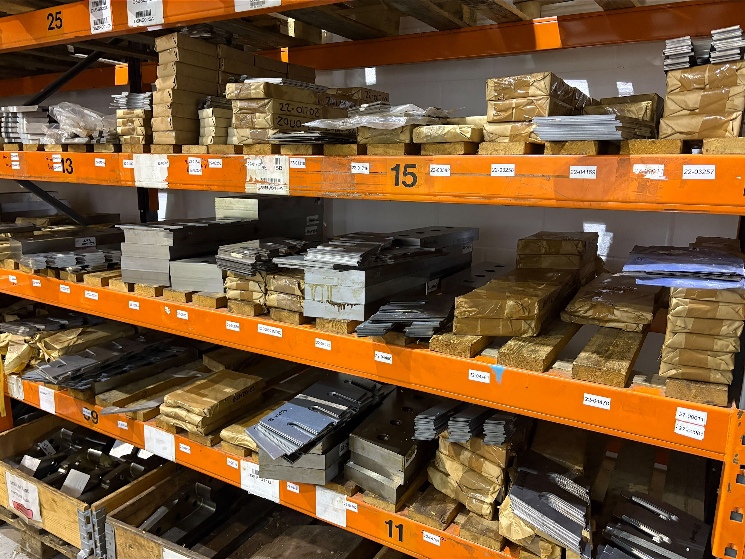 The inside of Hydraulic Attachment Services with shelves filled with shear blades.